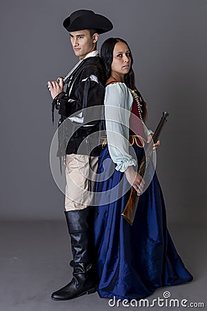 A pirate couple holding guns against a grey backdrop Stock Photo