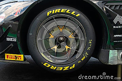 Pirelli racing tire on touring car wheel close up on track yellow name logo side view Editorial Stock Photo