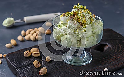Pistachio ice cream with pistachio nuts glass ice-cream bowl on a dark background, horizontal photo Stock Photo
