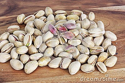 Pistachio nuts unhusked on the bench Stock Photo