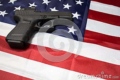 A pistol on the American flag. Gun laws in USA. Handgun, self defense. Stock Photo