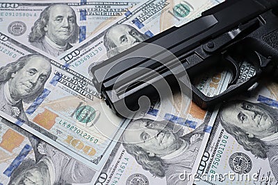 Pistol gun on 100 us dollar banknote,illegal money by gangster dirty job criminal and terrorism concept Stock Photo