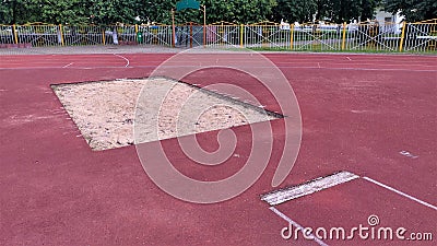 A pit with sand for long jumps has been built at the stadium. A wooden board was laid as a line of push off before the jump. The s Stock Photo