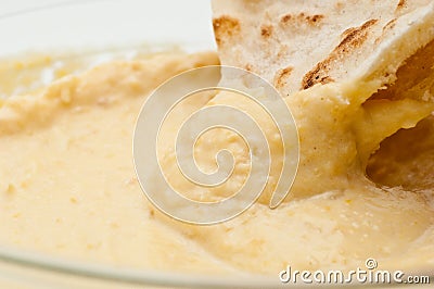 Pita bread dipped in humus Stock Photo