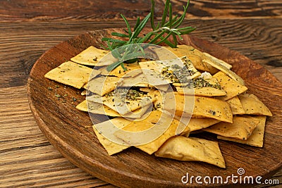 Pita Chips Pile on Wood Plate, Small Wheat Tortillas, Crunchy Flat Bread, Spicy Mediterranean Wheat Snack Stock Photo