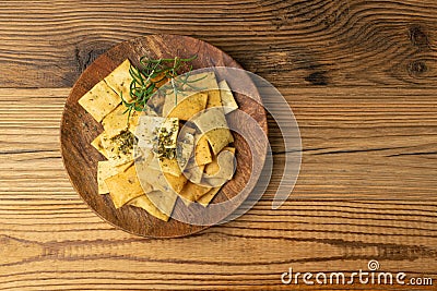 Pita Chips Pile on Wood Plate, Small Wheat Tortillas, Crunchy Flat Bread, Spicy Mediterranean Wheat Snack Stock Photo