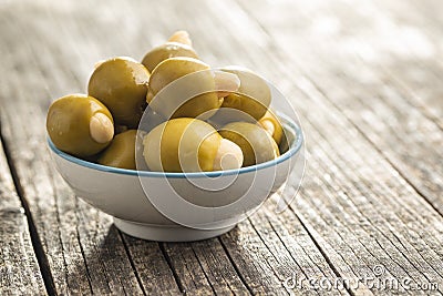 Pitted green olives stuffed with almonds in bowl Stock Photo