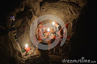 Pixie gang eating a Christmas meal in an underground den, only with light from the candles Stock Photo