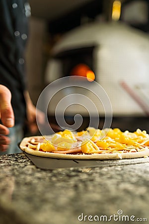 Pizaiolo Praparing Pizza for Baking in Wood Fired Oven Stock Photo