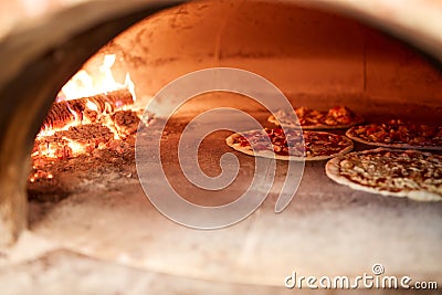 Pizza baking in oven at pizzeria Stock Photo