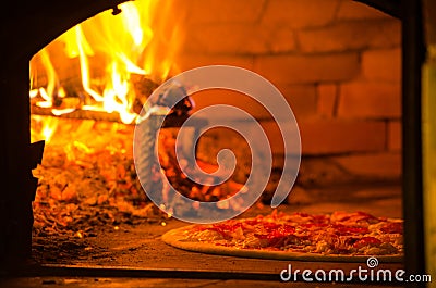 Pizza baking in wood fired oven Stock Photo