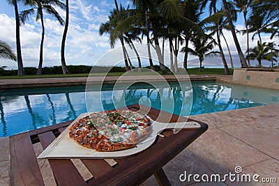 Pizza and beer by the poolside in Hawaii Stock Photo