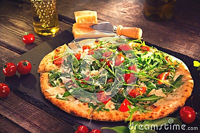 Pizza Caprese with arugula, cheese, yoghurt and cherry tomatoes Stock Photo