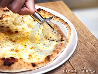 Pizza Chesse topping Hand cutting with pizza cutter Stock Photo