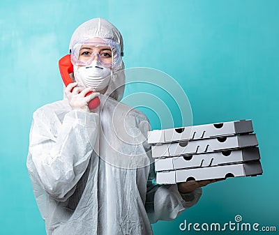 Pizza delivery girl with boxes in protective suit on blue background Stock Photo