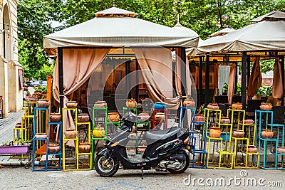 Pizza delivery man moped at a small cafe Editorial Stock Photo