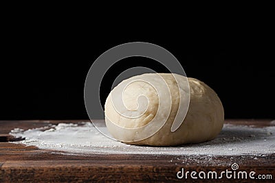 Pizza dough or baking on a dark black background of wood. Baking bread, pizza, pasta. Recipe from chef cooks pizza. Italian home c Stock Photo