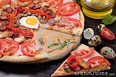 Pizza with egg, ham, meat and tomatoes on wooden background Stock Photo