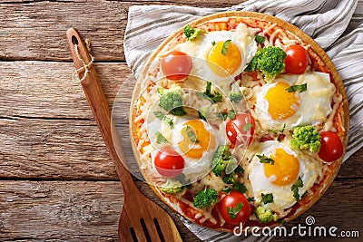 Pizza with eggs, cheese, broccoli, tomatoes and herbs close-up. Stock Photo