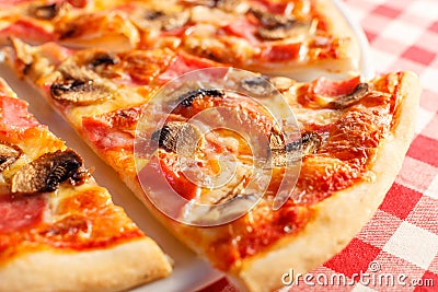 Pizza with ham and mushrooms. Delicious hot food sliced and served on white platter. Menu photo, Italian fast food. Stock Photo