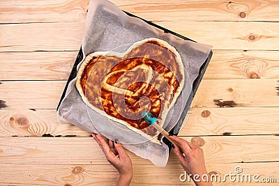 Pizza heart love Valentine`s Day romantic Italian restaurant dinner food. Prosciutto, olives, tomatoes, parsley, basil Stock Photo