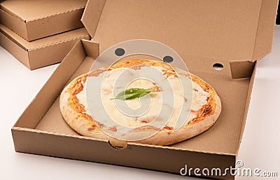 Pizza inside open box on tall stack of delivery boxes Stock Photo
