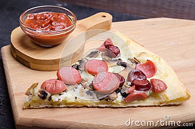 Pizza slice with mozzarella cheese, sausage and pepper on a wooden plate Stock Photo