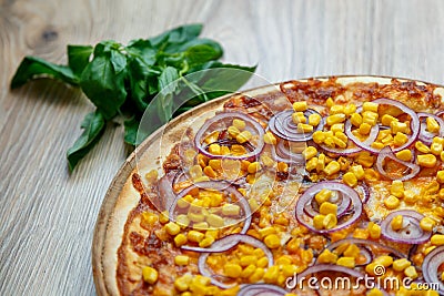 Pizza with red sauce, ham, mozarella, corn and onion rings detail Stock Photo