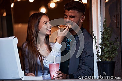 Pizza, restaurant and happy couple feeding fast food on playful romantic date for Valentines Day, bonding and quality Stock Photo