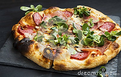 Pizza salami,cheese and ham with cornsalad leaves Stock Photo