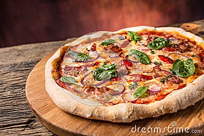 Pizza. Tasty fresh italian pizza with bacon cihili pepper spinach and onion served on old wooden table Stock Photo