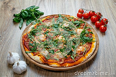 Pizza with tomato sauce, shrimp, garlic, arugula and cheese top angle view with garlic, cherry tomatoes and spinach Stock Photo