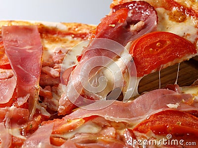 Pizza with tomatoes and meat. Slice of pizza with cheese and jamon. Italian cuisine Stock Photo