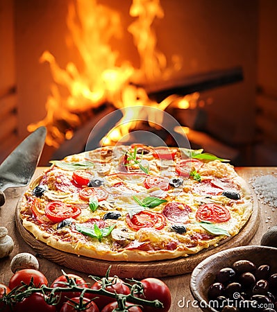 Pizza. Wood-fired oven on the background. Stock Photo