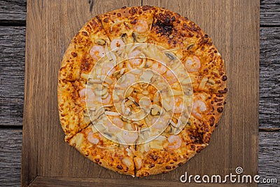 Pizza on wood for making background There is space to put letters all around. Stock Photo