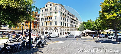 Pl. Theotoki in Corfu: Intersection with People Crossing, Cars Moving, and Scooters Parked Editorial Stock Photo