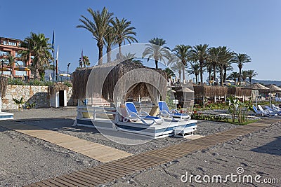 Place on the beach with sun beds and a gazebo with a thatched roof Stock Photo