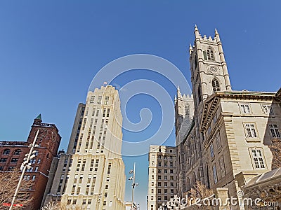 Aldred building and detail of Notre Dame basilica in Montreal Editorial Stock Photo