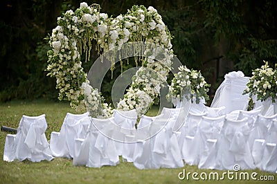 Place decorated for the wedding ceremony with heart arch from white flowers. Outdoors setup Stock Photo