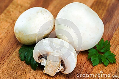 Place the sliced and whole edible, delicious porcini mushrooms and parsley on a wooden cutting Board Stock Photo