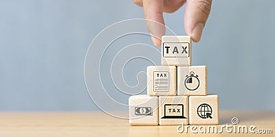 Place tax icon in wooden cube for income tax return and submit tax for online tax payment document to government, tax return Stock Photo