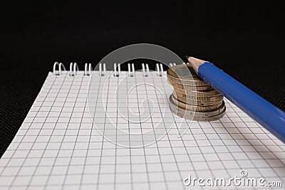 place for text, notebook, graph with pen and euro coins. Close-up of a pen and euro coins on top of a financial graph Stock Photo