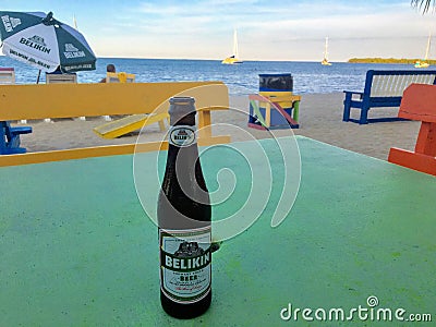 Placencia, Belize - May 26th, 2018: A cool tasty bottle of Belikin beer resting on a table along the beautiful sandy beaches of P Editorial Stock Photo