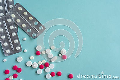 Placer multi-colored, white and pink pills of various shapes on a blue background. Medical concept. pharmacy Disease Stock Photo