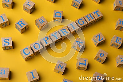 Plagiarism concept. Word Copyright made of wooden cubes with letters on yellow background Stock Photo