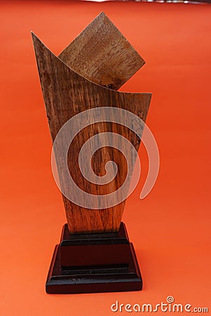 A plain award plaque made of wood on an orange background and used as a keepsake. Suitable for Awards, trophies, certificates, web Stock Photo