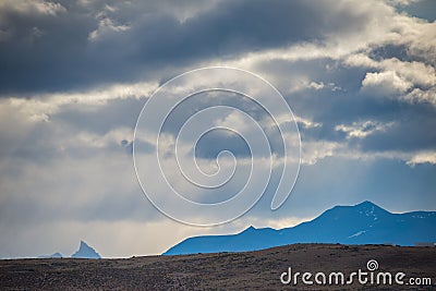 Plain on a background of silhouettes of mountains. Shevelev. Stock Photo
