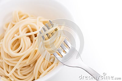 Plain cooked spaghetti pasta in white bowl and on fork, on white background. Stock Photo