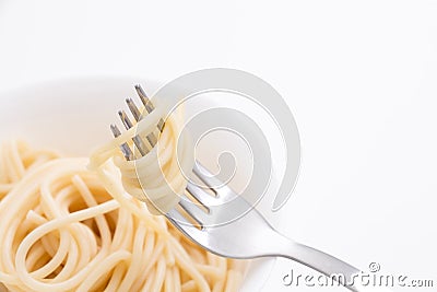 Plain cooked spaghetti pasta in white bowl and on fork, on white background. Stock Photo