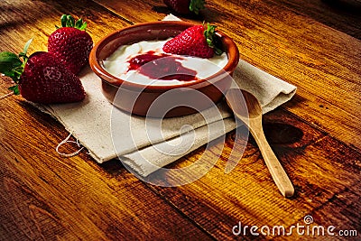 Plain yogurt with strawberry jam and strawberries, a delicious simple and healthy dessert from our Mediterranean diet Stock Photo